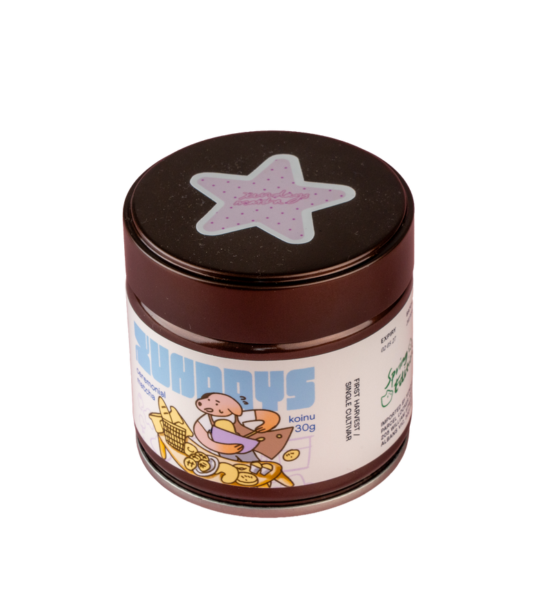 Koinu Matcha tin by xundays with a lilac star lid and illustrated label