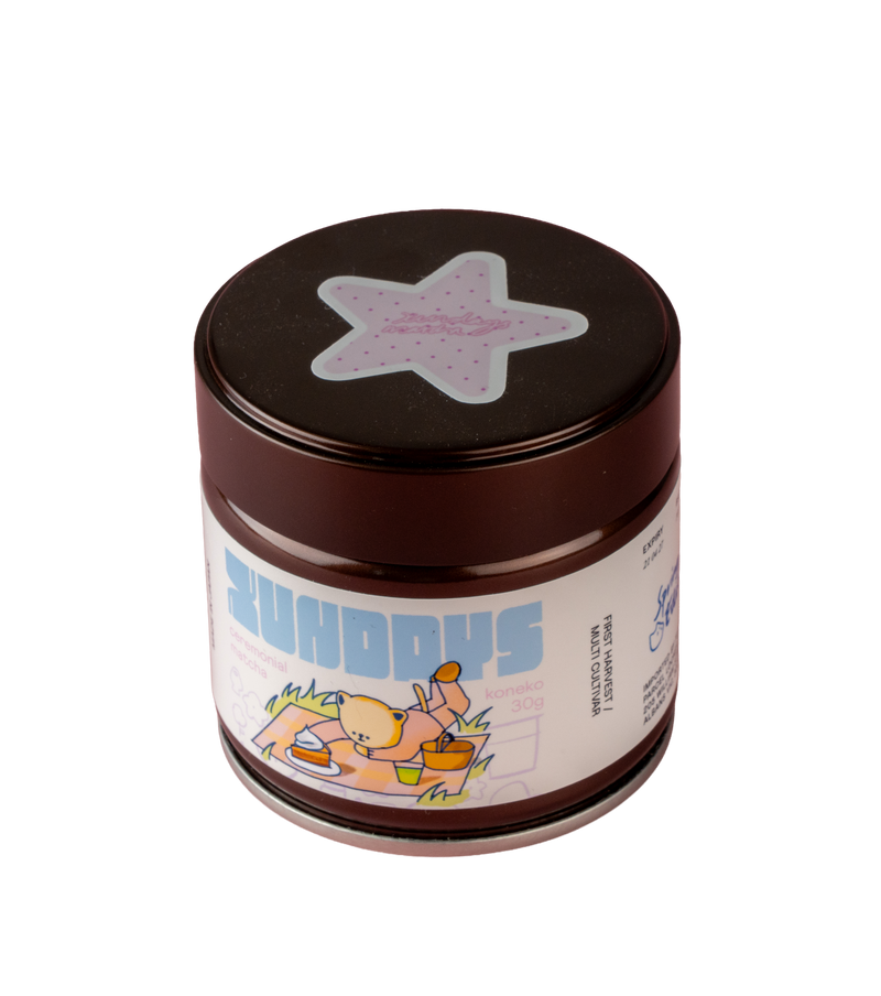 Koneko Matcha tin by xundays with a lilac star lid and illustrated label